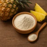 Bromelain powder in a wooden bowl next to a fresh pineapple