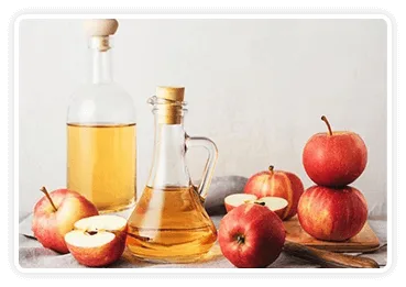 Apple cider vinegar in a glass bottle with fresh apples