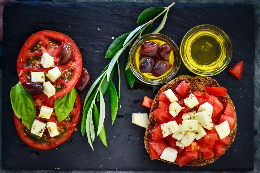 Tomato, basil and olive oil on a slate board, a Mediterranean-style heart-healthy plate