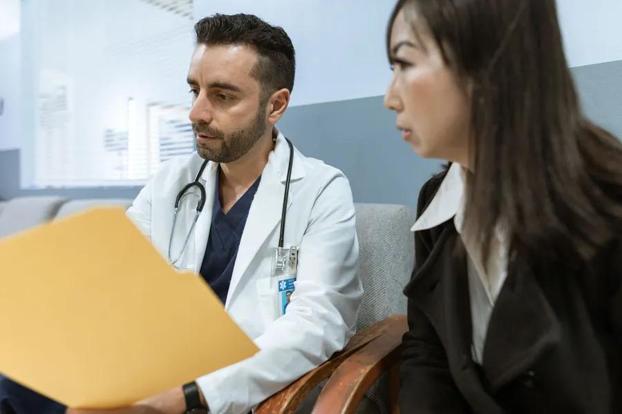 A doctor reviewing a patient's chart with her during a consultation