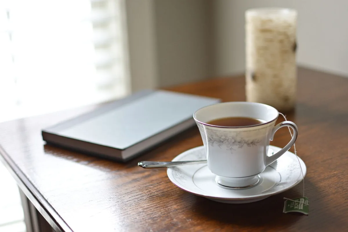 A calm morning ritual with tea and a journal on a wooden table