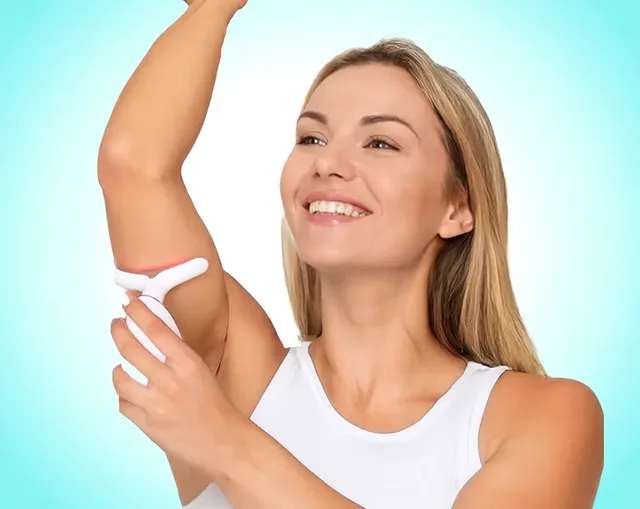Smiling woman gliding the MyoGlow device over the inside of her raised upper arm